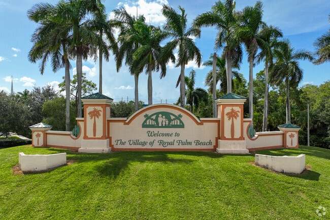 The grand welcoming Royal Palm Beach neighborhood signage in front of a large lake.
