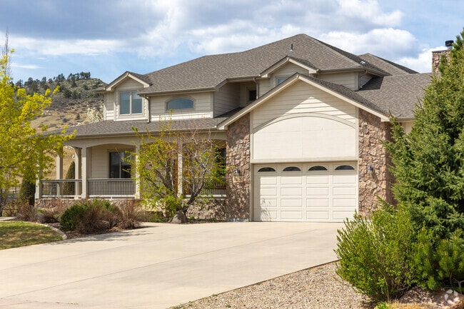 This home in the Ponds at Overland features amazing stone work and a covered porch.