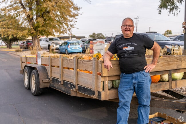 A vendor sits outside of the Junkin' Market Days event with a trailer full of pumpkins.