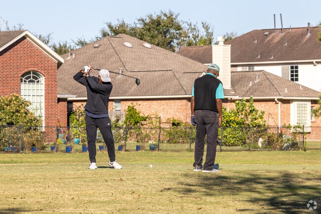 Two men enjoy a round of golf at the Pearland Golf Club in Pearland.
