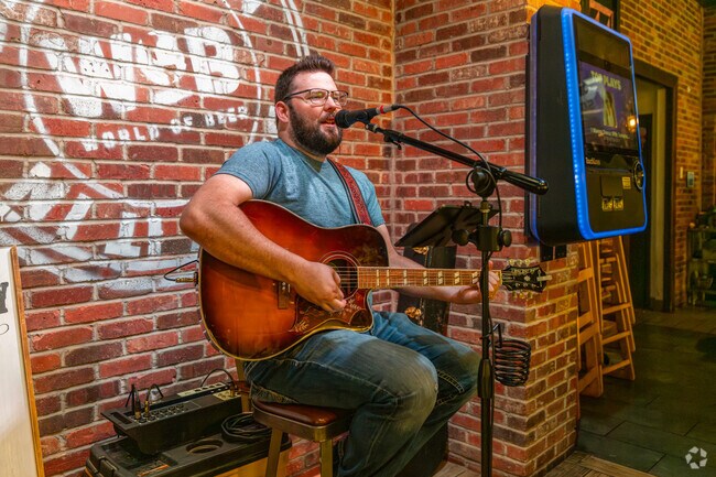 A performer sings and plays for the guests at World of Beer Bar & Kitchen in West End.
