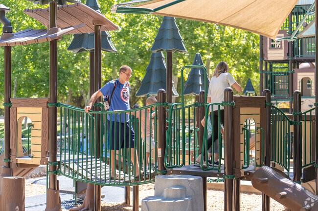 A family enjoys exploring the play structure at Creekside Park.