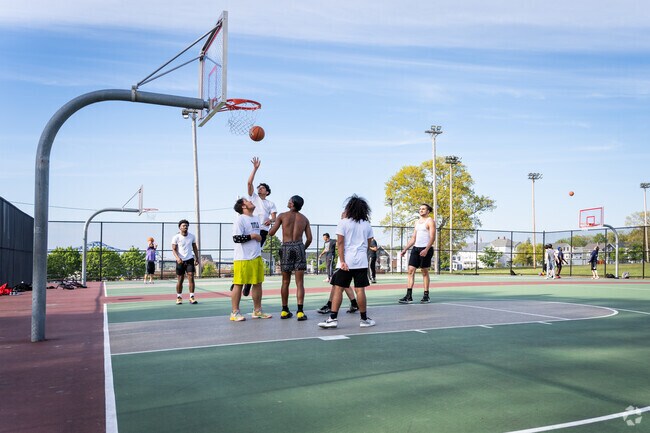 A group of young teenagers is playing basketball in Kennedy Park, close to North Tiverton, RI.