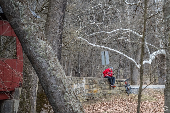 A cyclist takes a break from riding on a trail in Fallowfield Township.