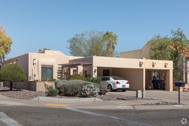 This Adobe-style home has an open carport and stucco exterior.