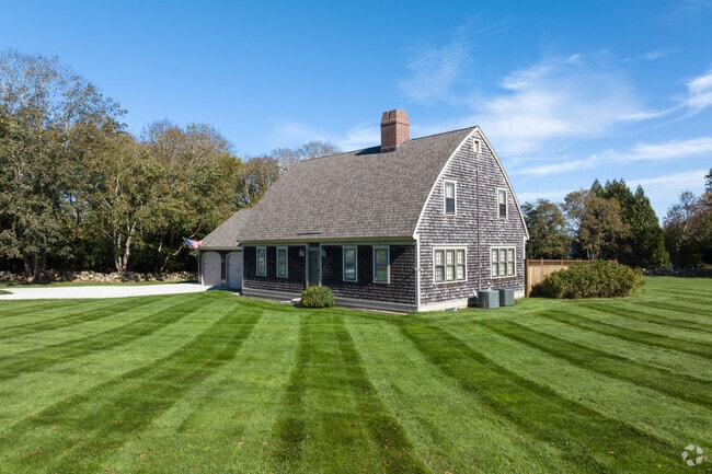 Lots of homes exterior are wood shingles with large plush lawns.