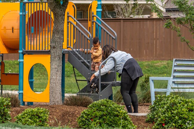 A mother and child play on the playground with their puppy in Rosharon.