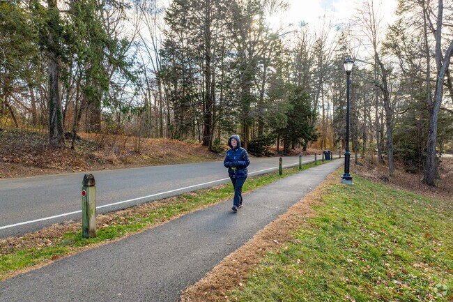 A person walks along the paved pathway at Elizabeth Park in West End.