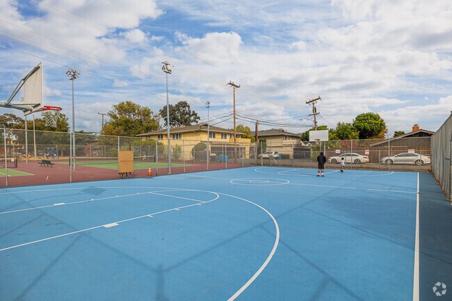 A father and son play basketball at Los Prados Park.