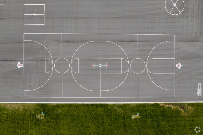 Basketball courts next to a grassy lawn at Peruvian Park Elementary.