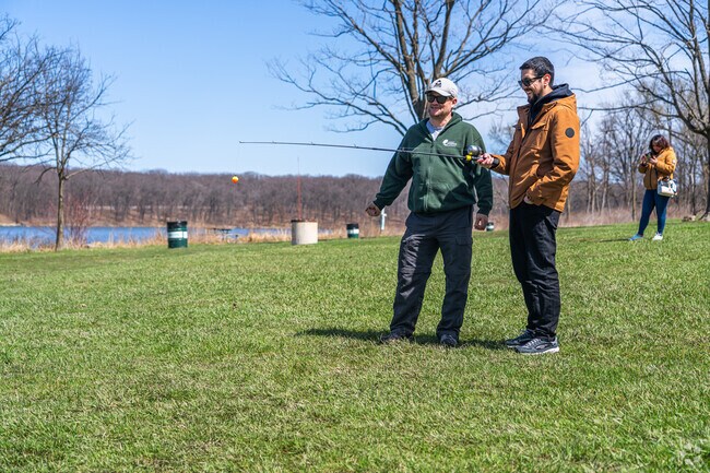 Rangers discuss fishing with visitors at Paw Paw Woods Nature Preserve.