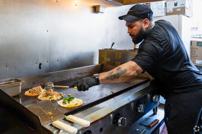 A chef at The Taco Spot in Grafton Hill prepares birria chicken tacos.