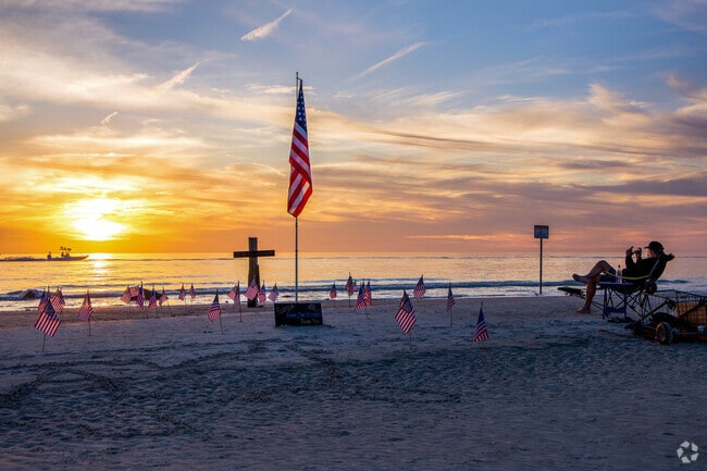 A local man pays tribute to fallen soldiers at sunset on Redington Shores beach.