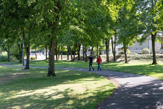 People walk along the path at Red Sunset Park on NE Red Sunset Dr in Gresham North-Central.