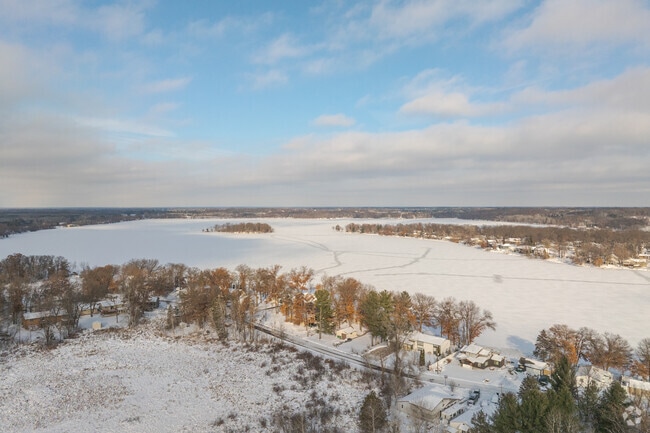 Scenic winter landscape of Fremont Lake in Zimmerman, Minnesota, where snow-covered shores meet a crisp, frozen lake.