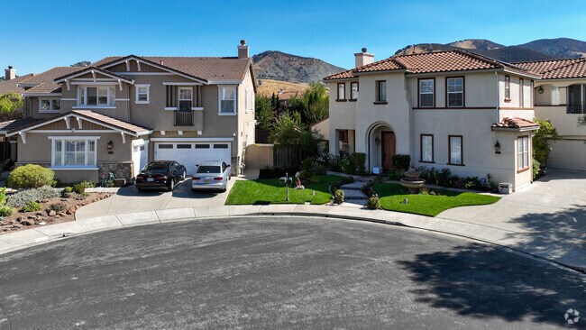 Two Spanish-style homes with the California Golden Hills in the background in the Highlands.