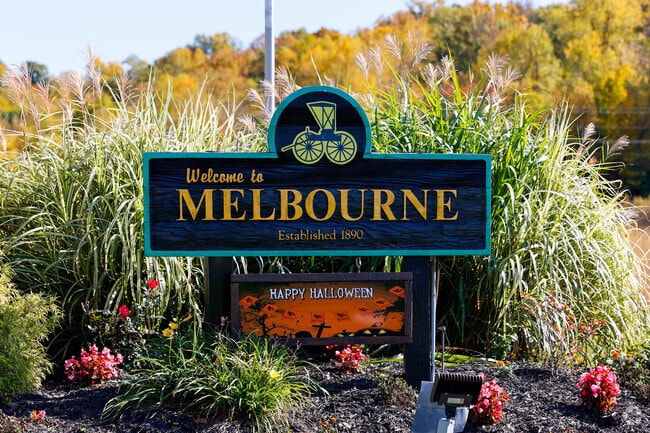 The entrance sign to Melbourne  is set against a beautifully kept garden.