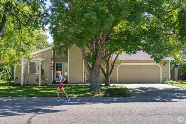 A Stonehenge jogger runs along the sidewalk outside a mid-20th-century home.