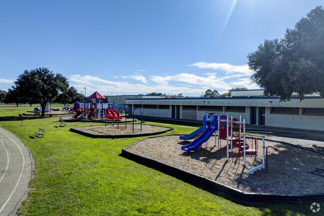 Students enjoy a colorful playground and a basketball court for recreation.
