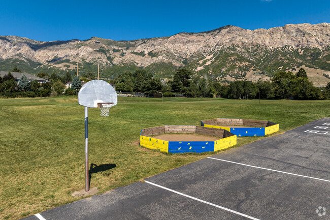 A basketball court borders a large field with an incredible Mountain View at Bates School.