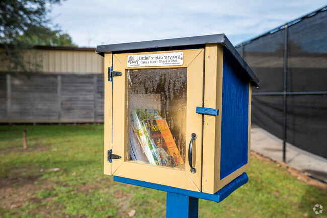 A free public library box sits alongside a street in Scott, Louisiana.