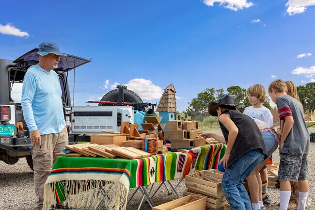 Kids examine the intricacy of wooden trinkets in Cañoncito.