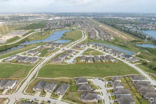 Neighborhood homes sit alongside small ponds in Webster, Texas.