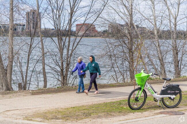A pair of people walking on the East Bde Maka Ska lake trail.