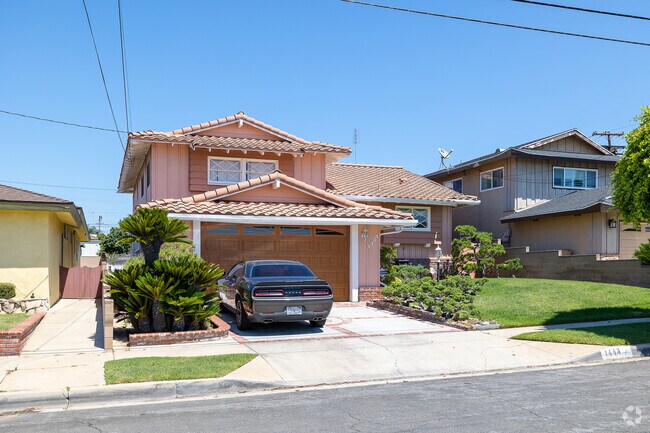 Two-story Spanish-style homes with orange-tiled roofs line the streets in Athens, CA.