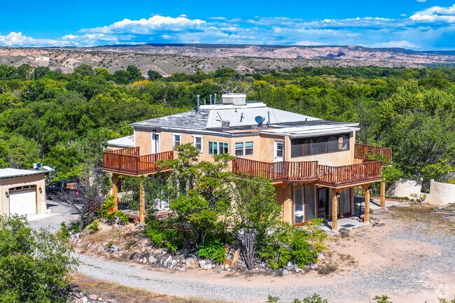 This two story home in Sombrillo sits atop a hill overlooking the lush valley below.