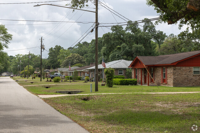 Mature trees stand over rows of ranch style homes in Creola, Alabama.