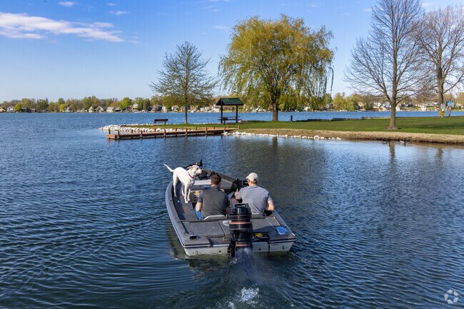 Boaters and a dog cruise past Pebble Beach Park on scenic Gages Lake.