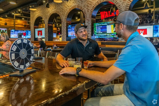 Friends drink at the bar at Walk On's Sports Bisteaux in West End.