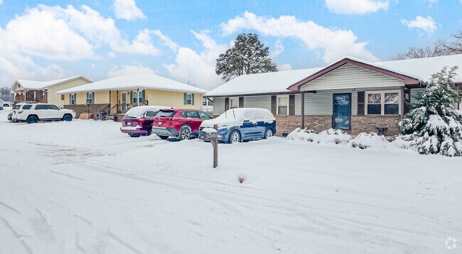 A row of mid-century houses is covered in snow after a winter storm in Buffalo Creek.