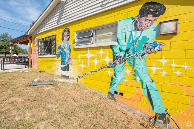 A mural depicting local artists from Augusta on the side of a building in Albion Acres.