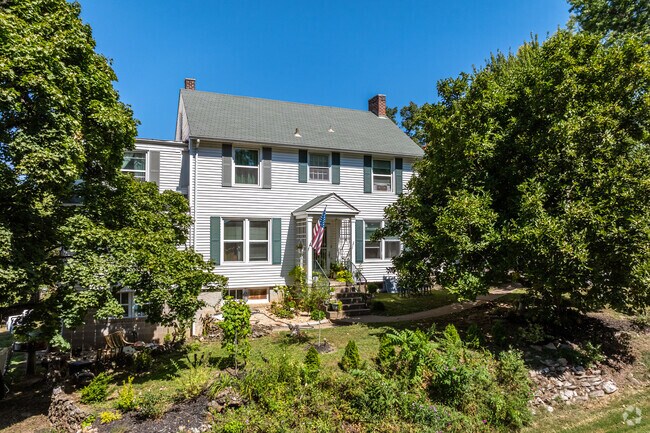 Colonial Revival-inspired homes shrouded in lush pines sit on hillsides in Hill Park.