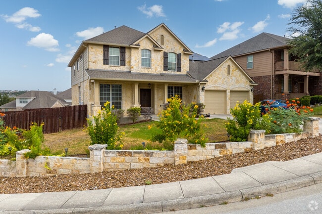 A beautiful array of flowers lines the street by this cottage-inspired home in Bulverde.