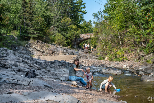 Families enjoy playing in the Lester River at Lester Park.