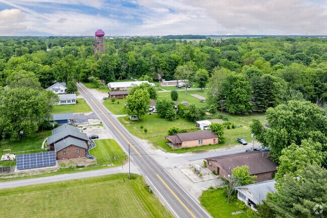 Saint Bernice homes often have larger lots with green space surrounded by tall trees.