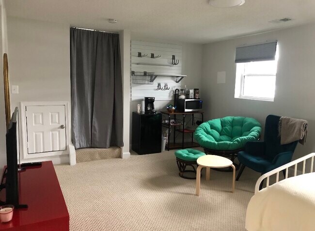 Sitting area, kitchenette, and curtains that lead to the main floor.