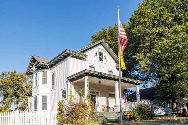 A large, older home sits under large trees as survivors of the 2011 tornado.