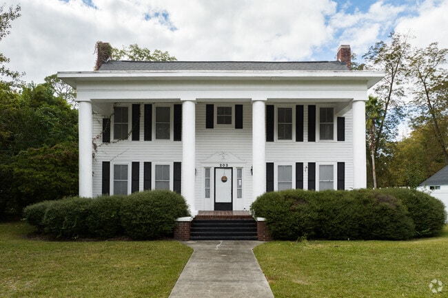 Large colonial homes in Pembroke feature double height columns and white facades.