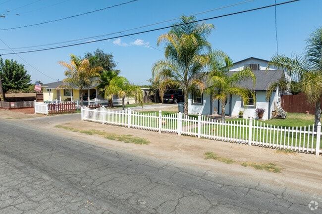 Midcentury bungalows sit beneath palm trees.