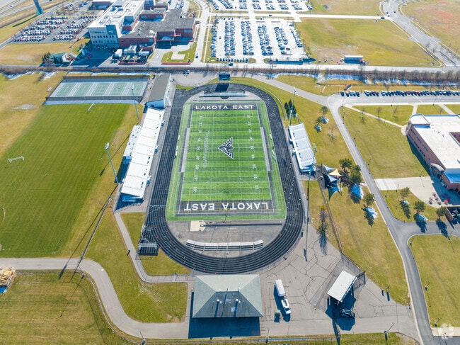 The Lakota East High School has a football field near the building.