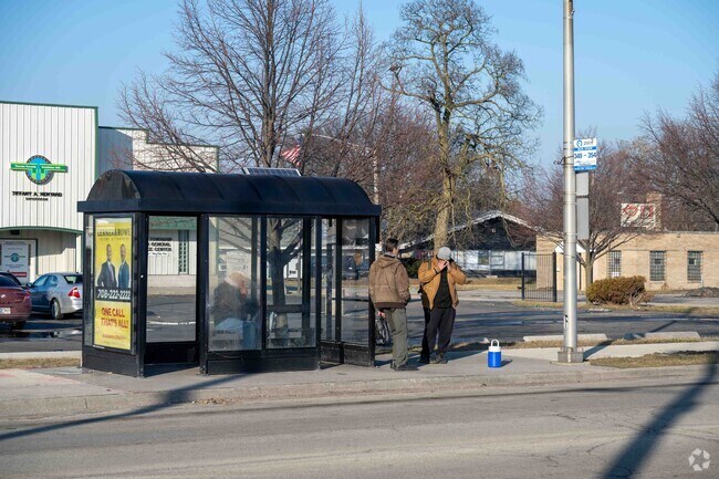A few people waiting for the bus in the quiet neighborhood of Phoenix, IL.
