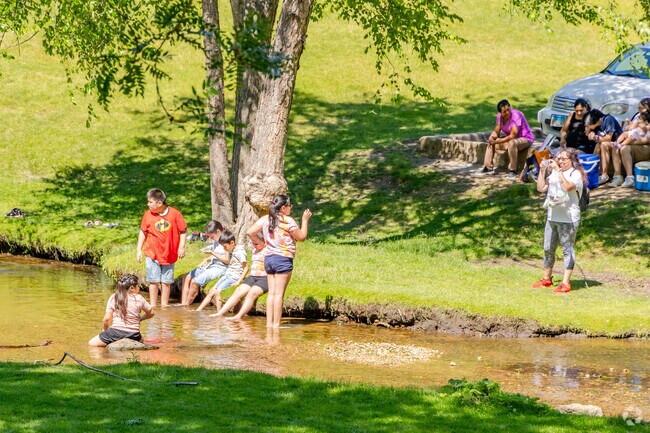 Parents grab the joy of children playing in the creek, a moment to cherish at Lords Park.