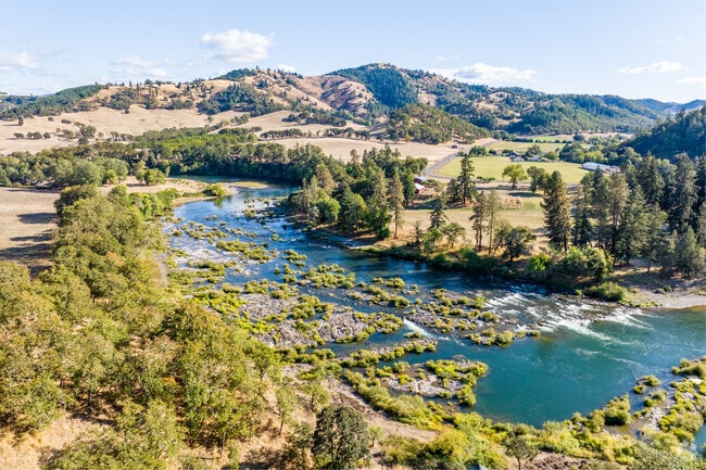 Experience tranquility along the banks of Umpqua River near the lush Eden Orchards.