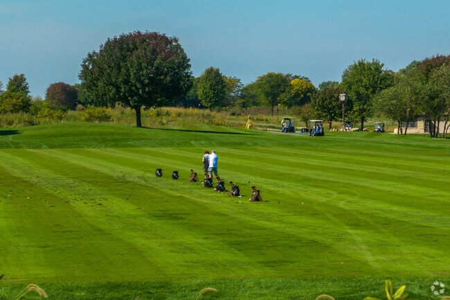Golfers warm up on the driving range before hitting the greens near Freedom Park.