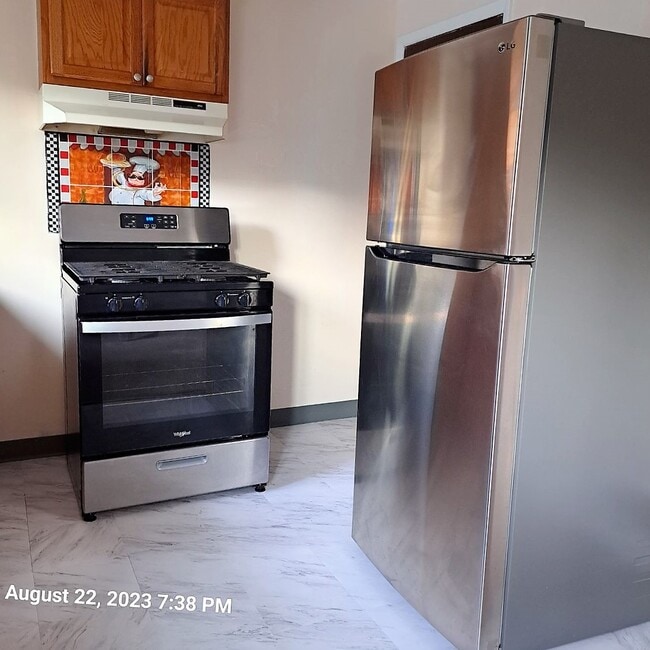 Kitchen with stainless range and refrigerator