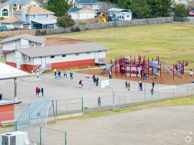Shining Mountain Elementary School school students enjoy recess on a colorful playground.